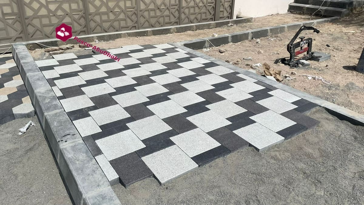 مدخل سيارات فيلا مرصوف بباسكو مربع رمادي فاتح وأسود أمام بوابة الفيلا